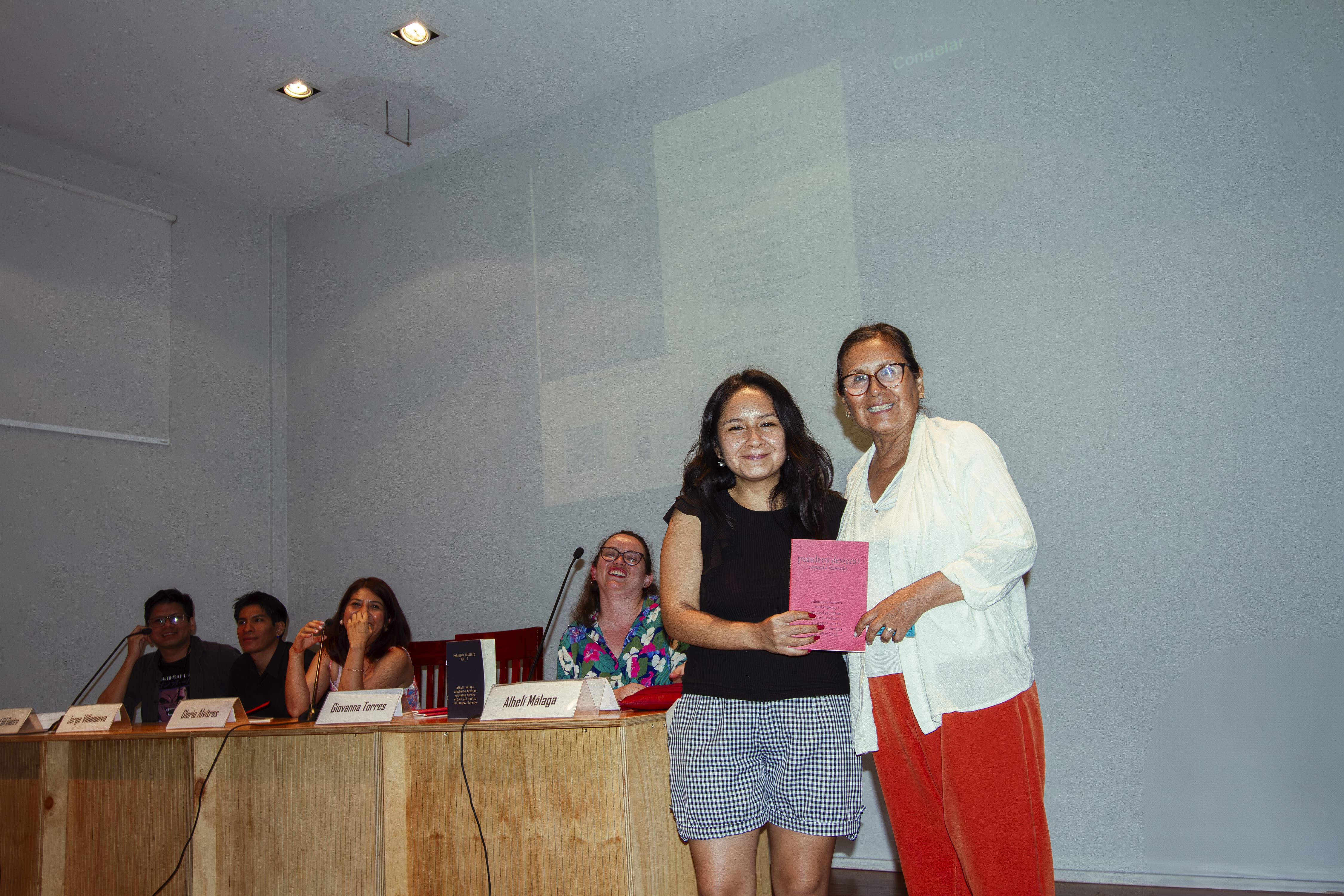 Giovanna Torres posa con la persona que ganó un ejemplar del libro en el marco de un sorteo express