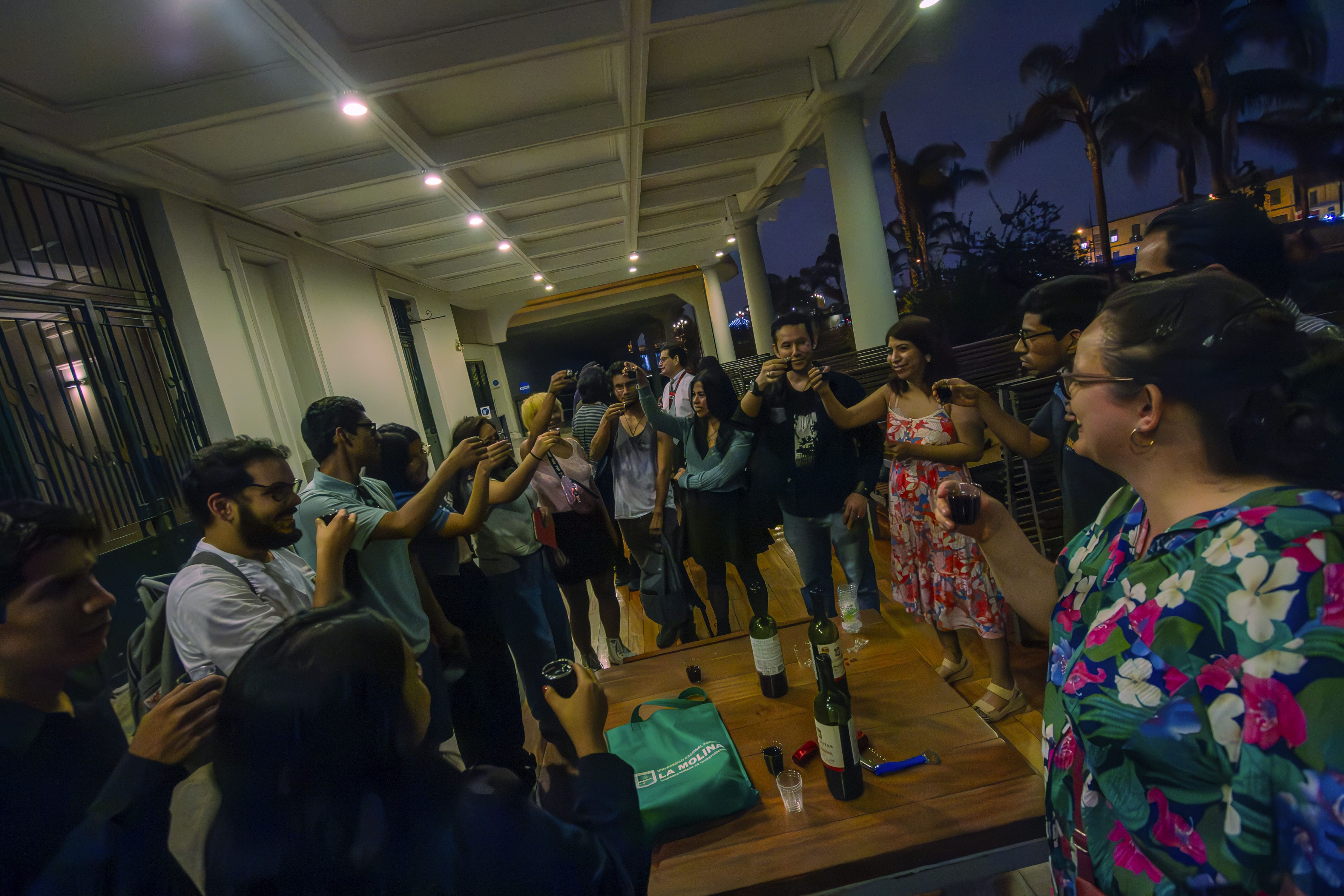 Los asistentes a la celebración brindan en la terraza de la Casa de la Literatura, se ve brazos alzados con copas